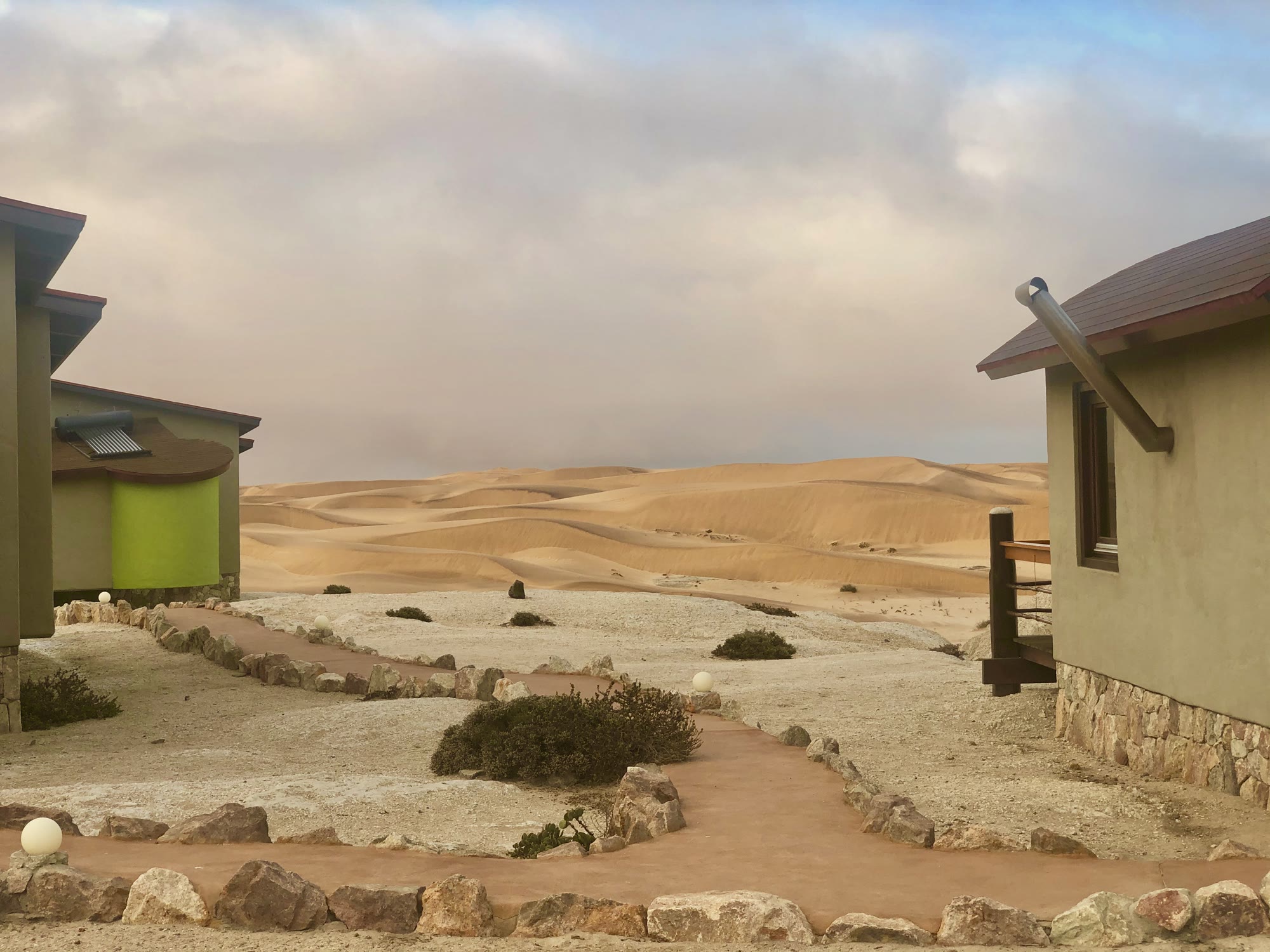Desert Breeze bungalows framing a view across the Namib dunes