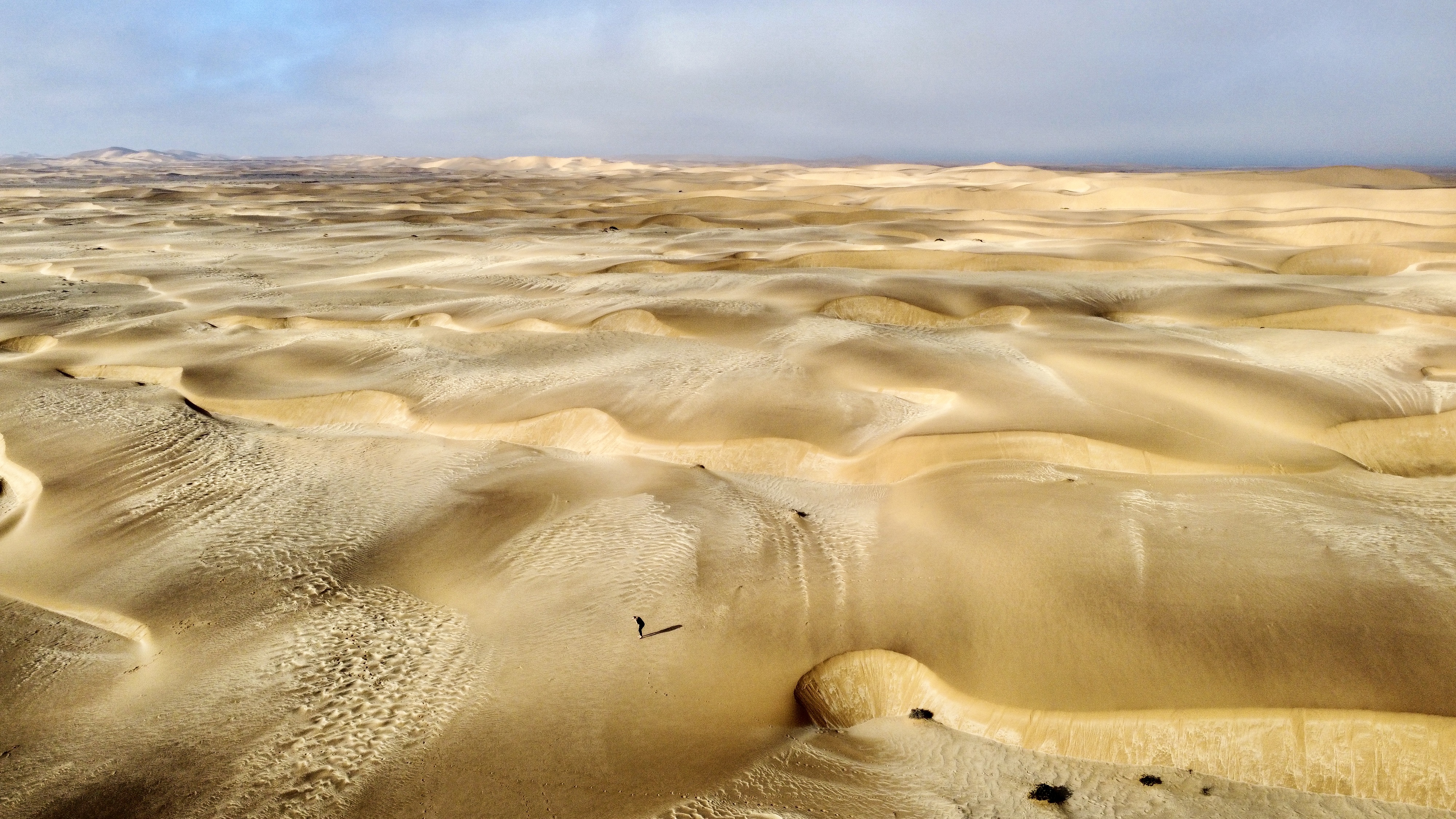 Aerial view across the Namib dunes beneath an open sky