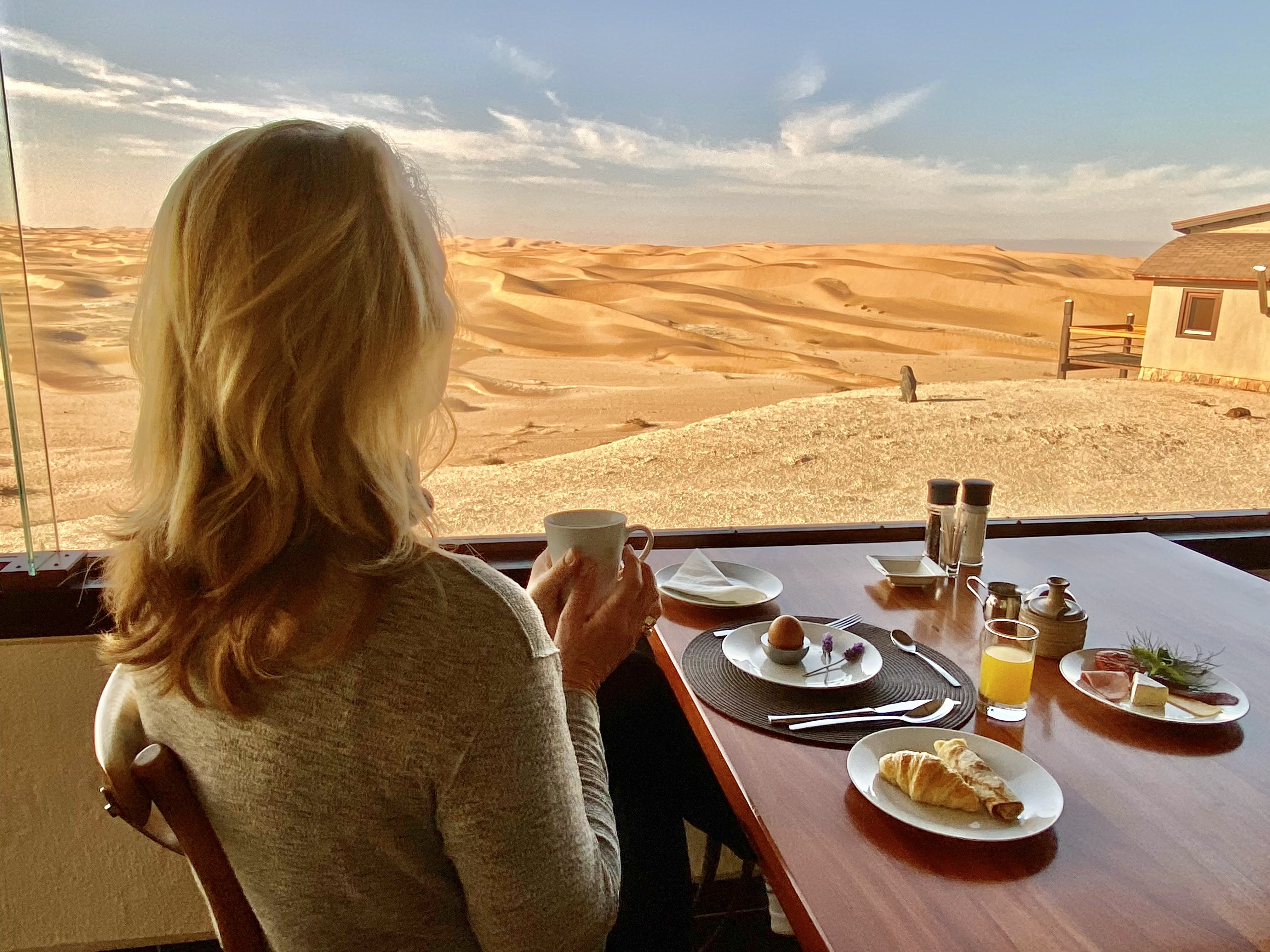 Guest enjoying breakfast overlooking the Namib dunes at Desert Breeze