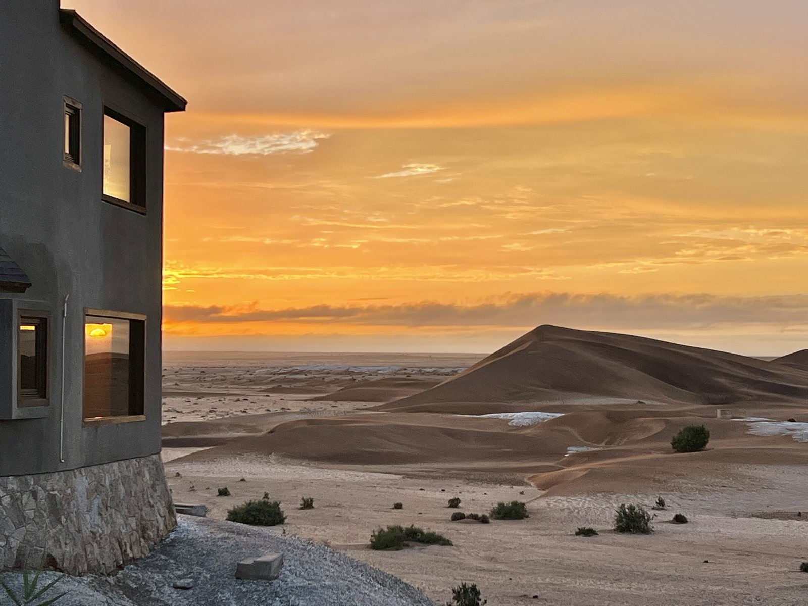 Desert Breeze architecture against a golden dune sunset