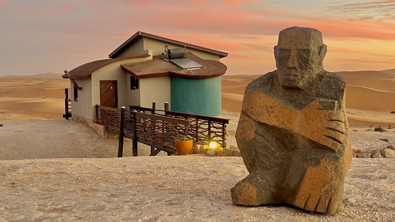 Desert Breeze sculpture and bungalow at sunset