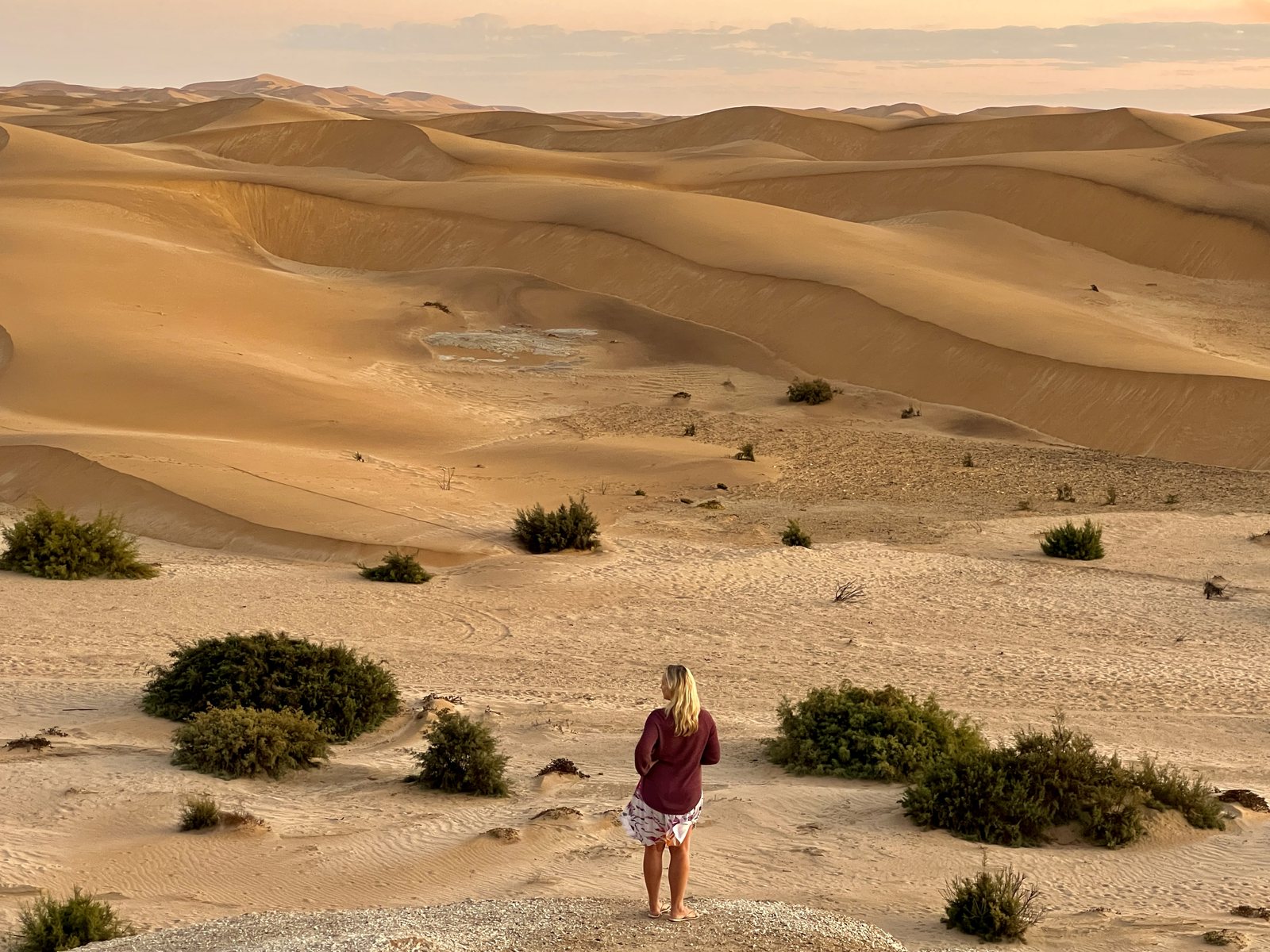 Guest walking through golden dunes below Desert Breeze