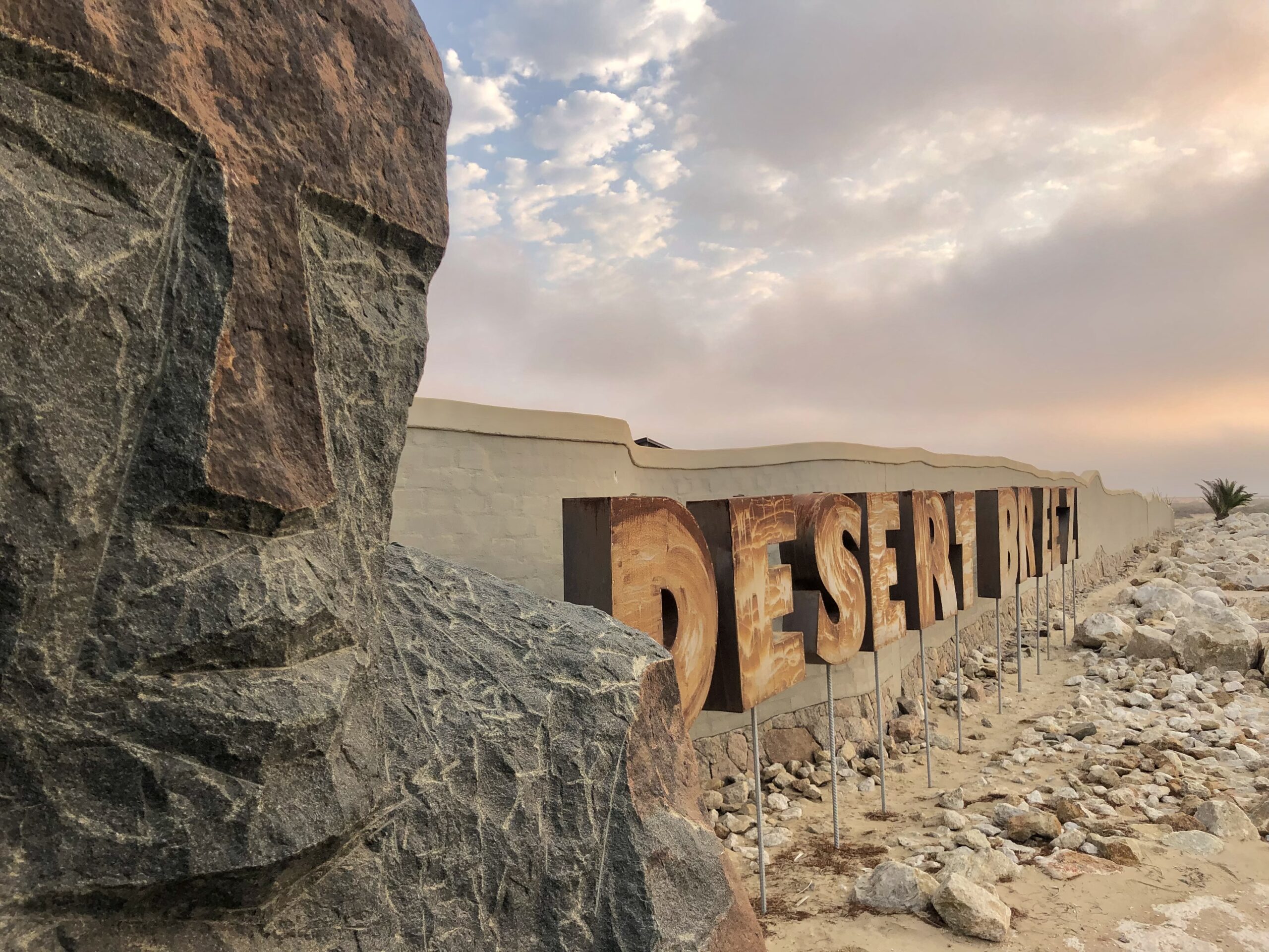 Desert Breeze stone sculpture and entrance sign beneath the desert sky